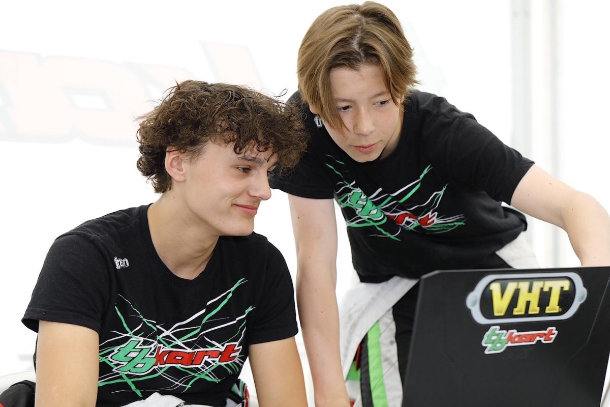 Two drivers of a dutch youth karting team watching a computer together